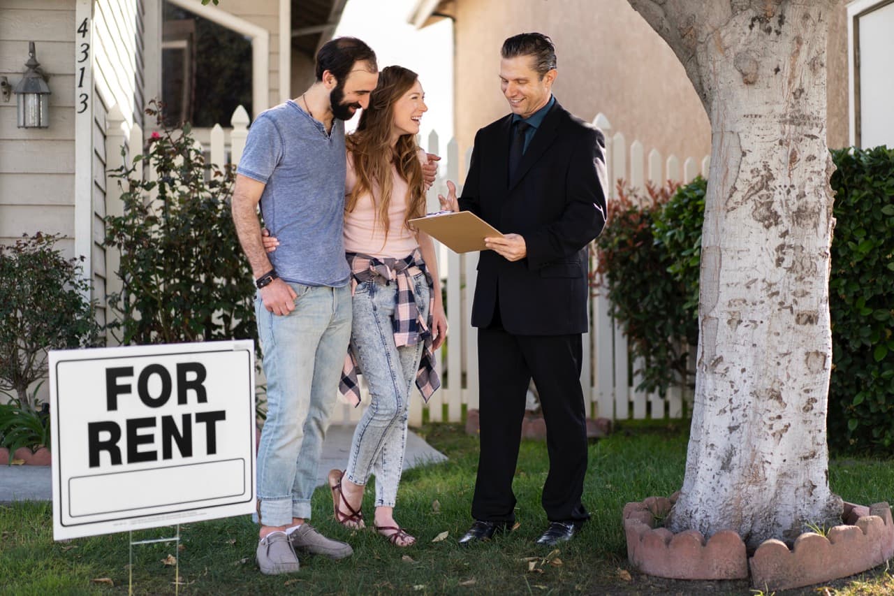 Couple signing lease papers with property manager